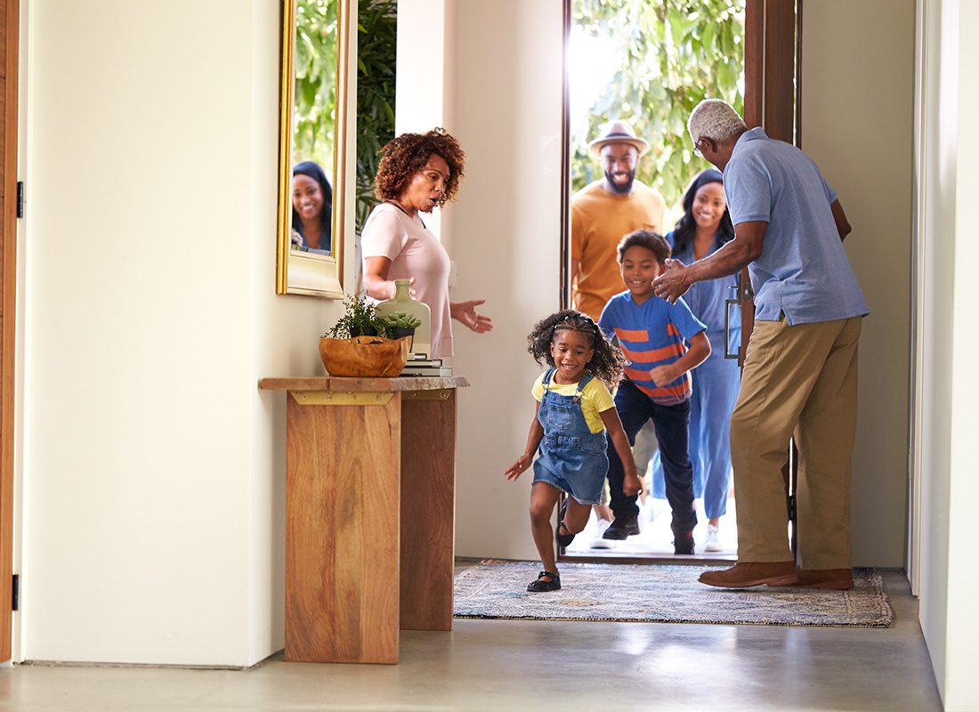 Personal Insurance - Young Children Run into a Home and are Greeted by Their Grandparents